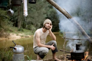 a man sitting in front of a campfire