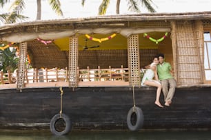 a man and a woman sitting on the back of a boat