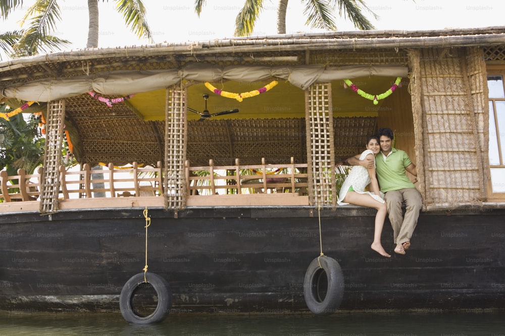 a man and a woman sitting on the back of a boat