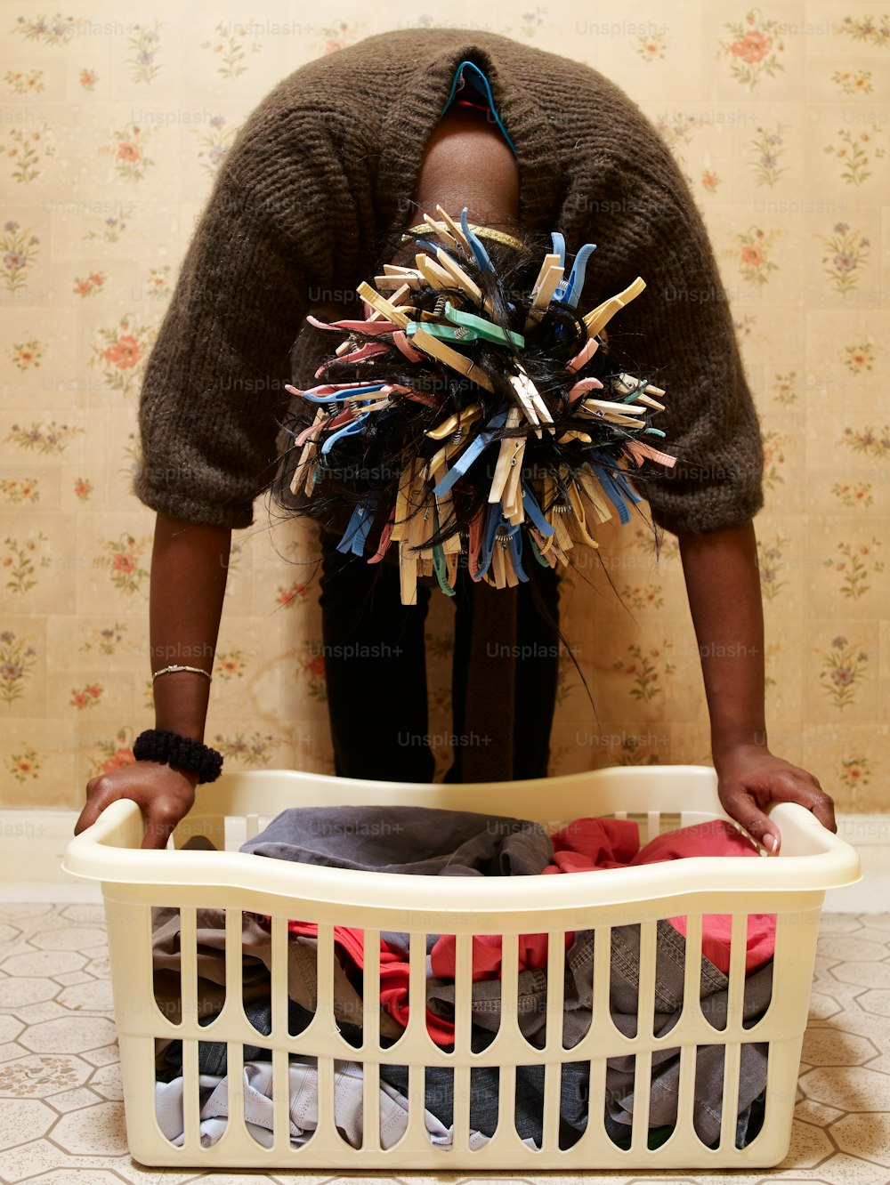 a woman standing in front of a laundry basket filled with clothes