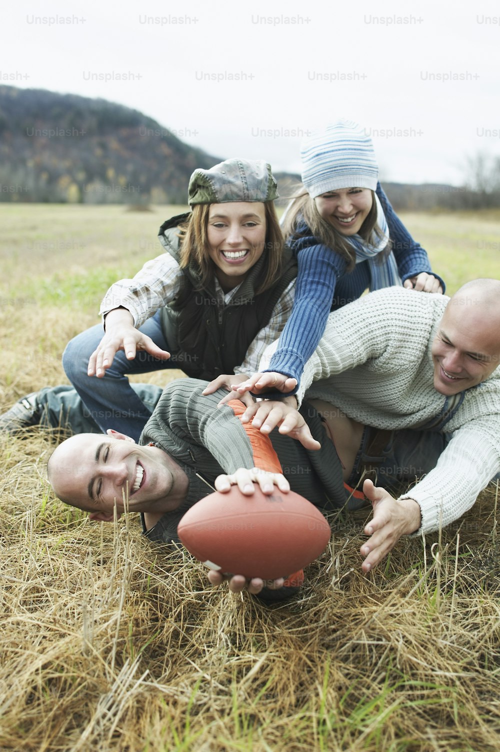 a group of people sitting in a field with a football