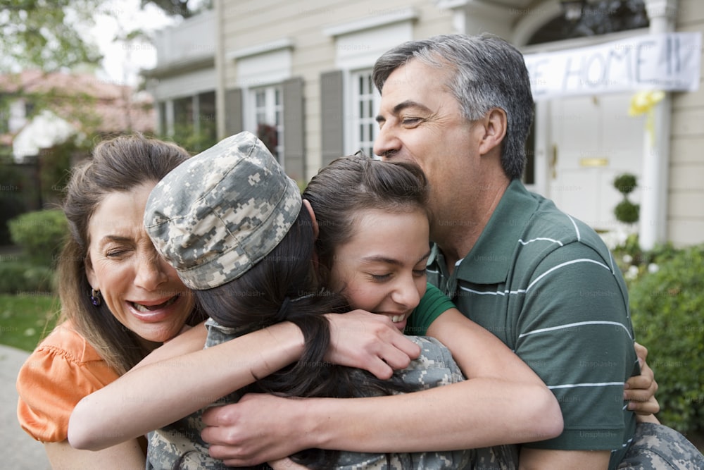a soldier hugging two women and a man