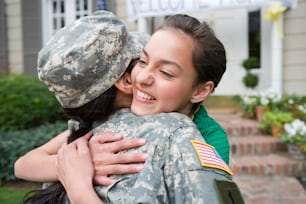 Une femme en uniforme militaire étreignant une autre femme