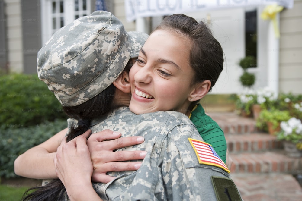 a woman in a military uniform hugging another woman
