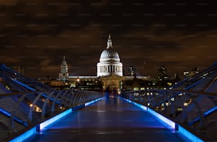 La Cattedrale di St. Paul e la passerella Millenium illuminate di notte a Londra, Regno Unito.