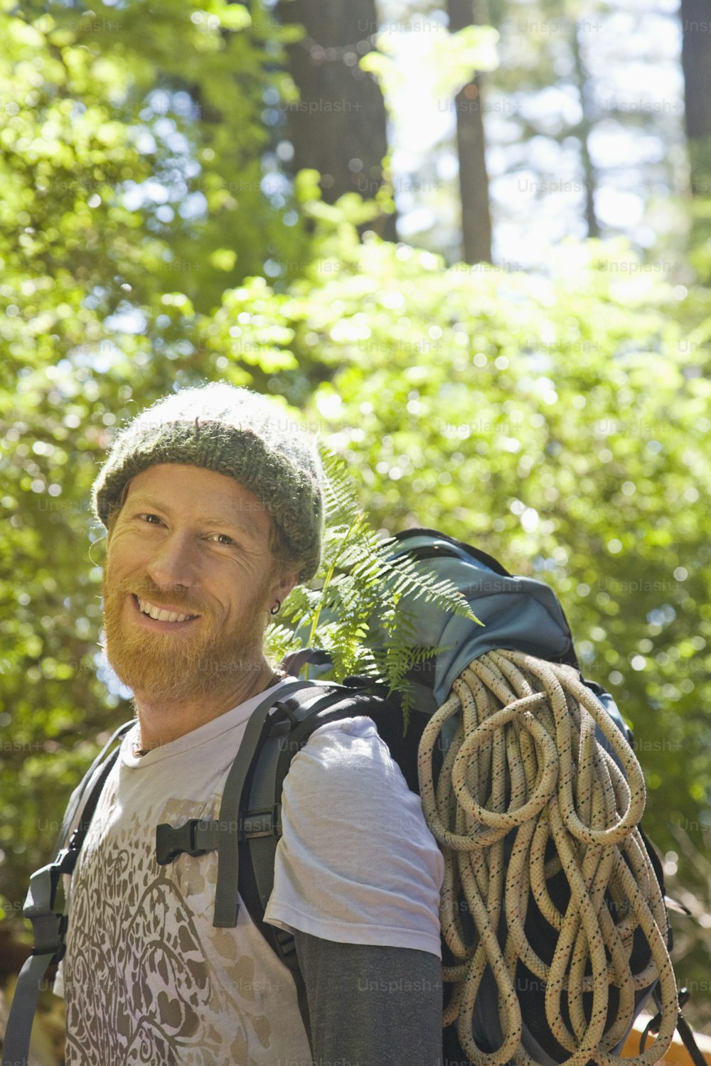 a man with a backpack and rope in the woods
