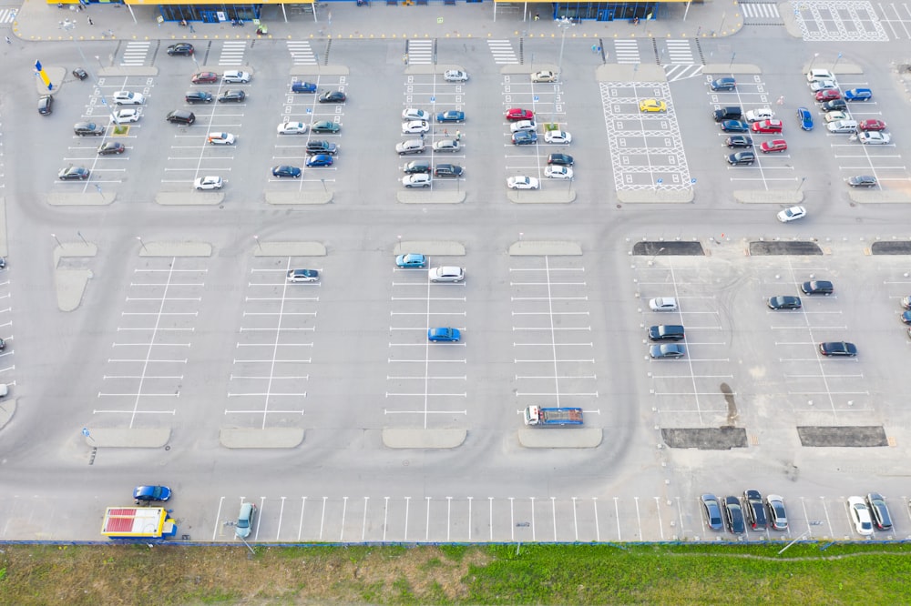 Aerial top down view of the parking lot with many cars of supermarket shoppers in the city grocery store