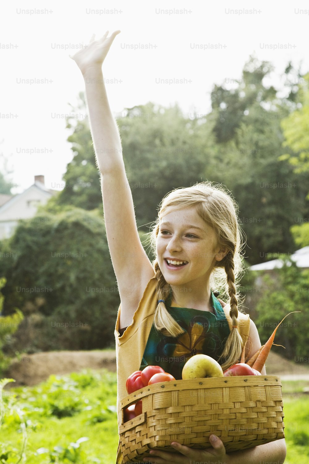 a little girl holding a basket full of fruit