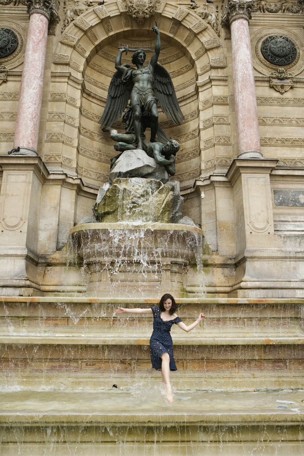 a woman is posing in front of a fountain