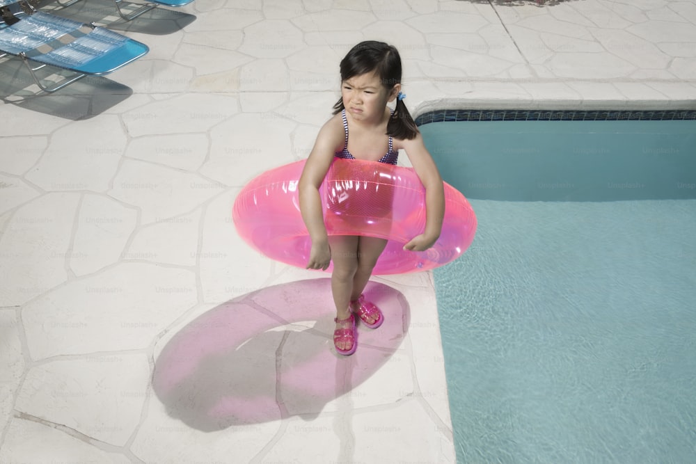 a little girl sitting on an inflatable pool float