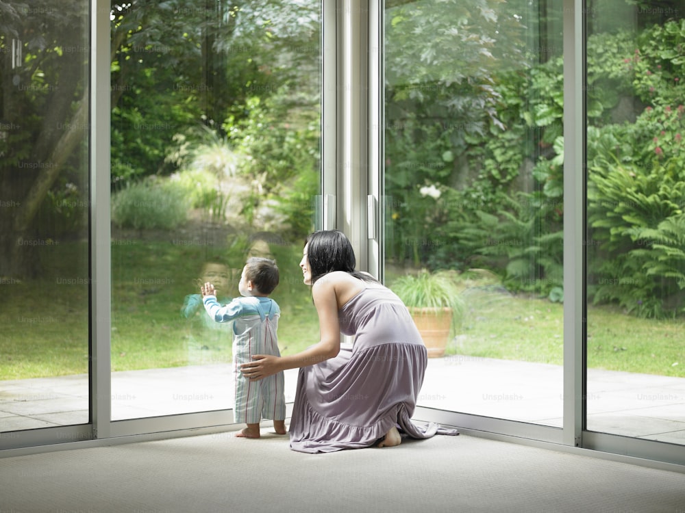 Mother and son looking out window