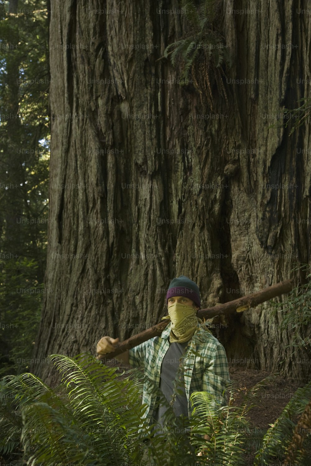 격자 무늬 셔츠를 입고 녹색 격자 무늬 모자를 쓴 남자가 앞에 서 있습니다.