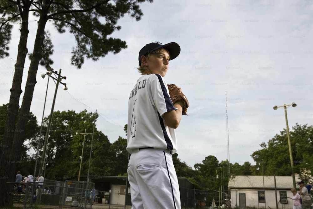 Retrato de joven jugador de béisbol con campo en el fondo