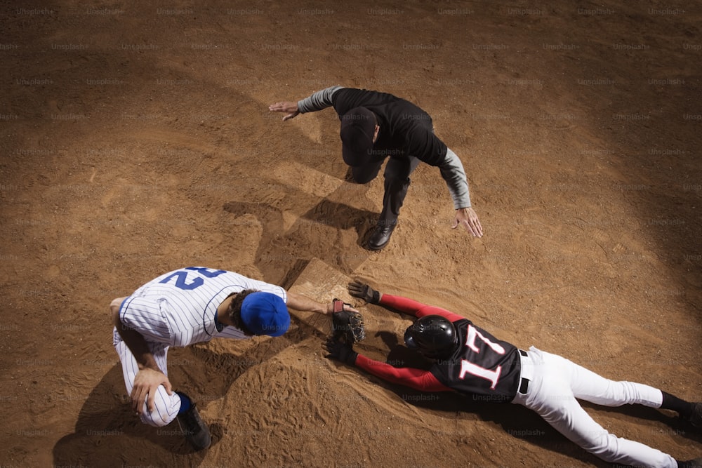 a couple of men standing on top of a dirt field