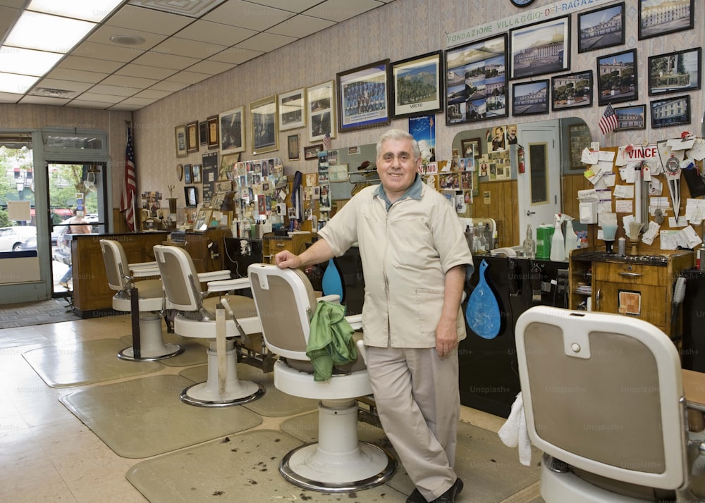 um homem em pé em uma barbearia ao lado de uma cadeira