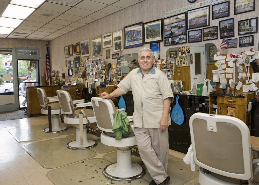 a man standing in a barber shop next to a chair