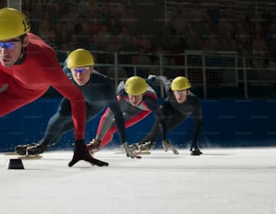 a group of men riding skateboards down a snow covered slope