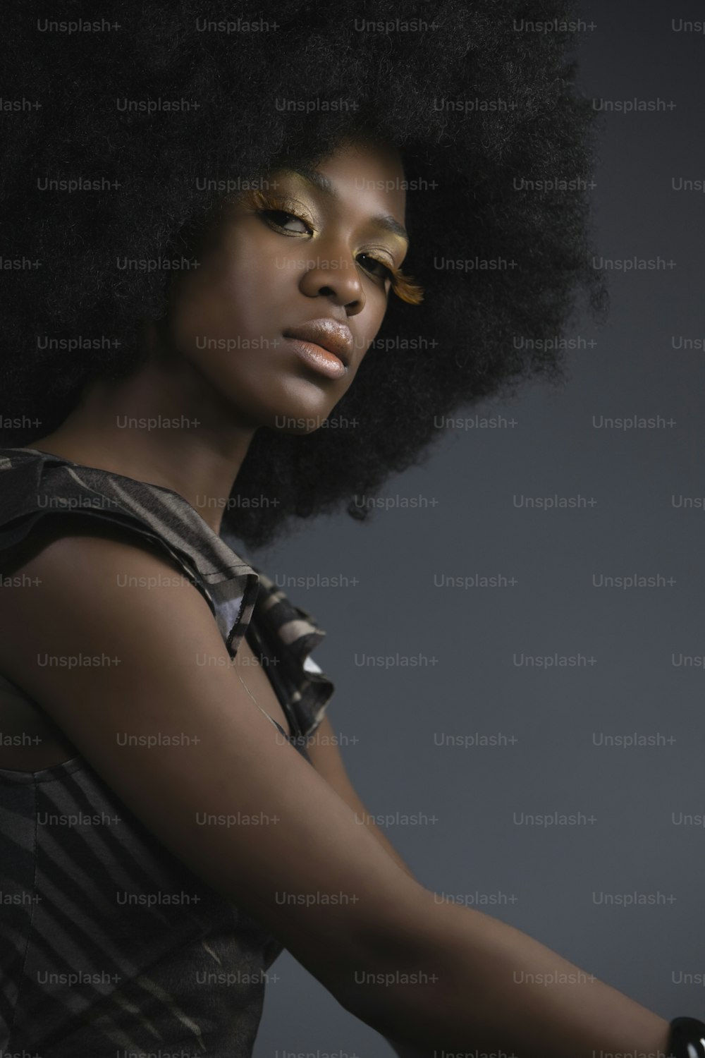 uma mulher com um afro segurando um telefone celular