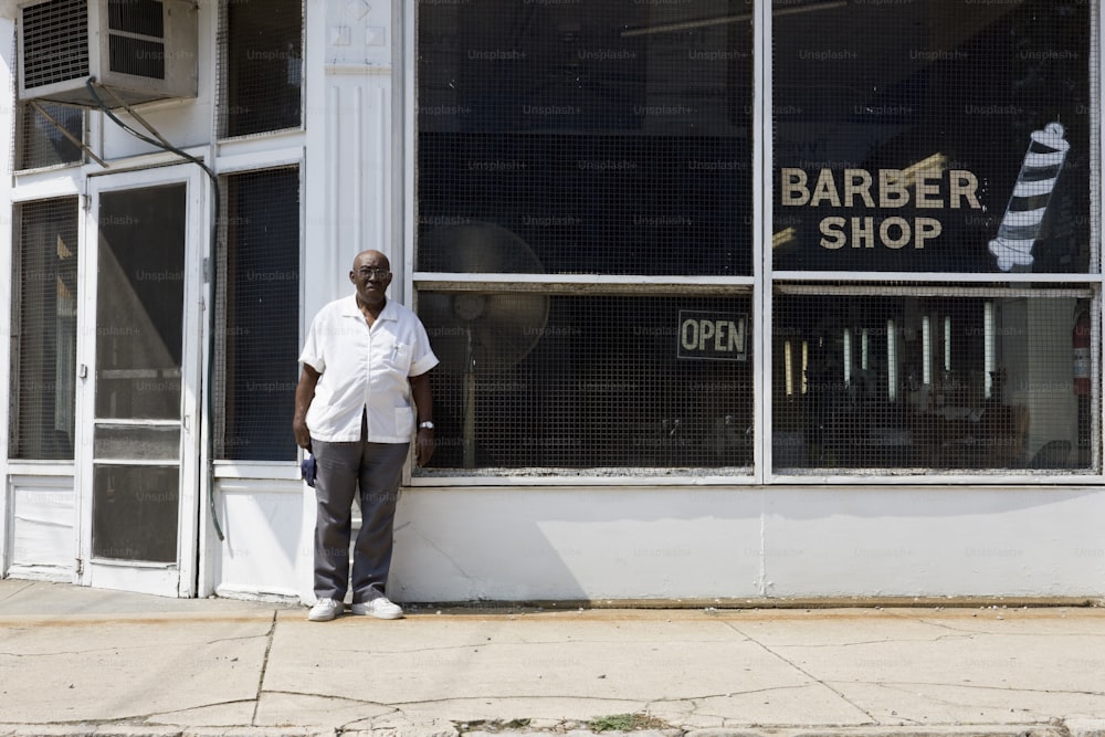 Barber standing in front of his barber shop