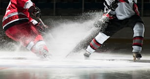 a couple of men playing a game of ice hockey