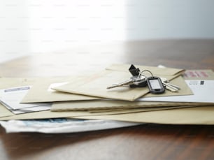 a pile of envelopes and keys on a table