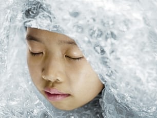 a woman with her eyes closed is covered in ice