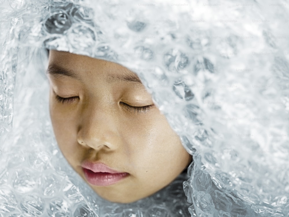 Eine Frau mit geschlossenen Augen ist mit Eis bedeckt