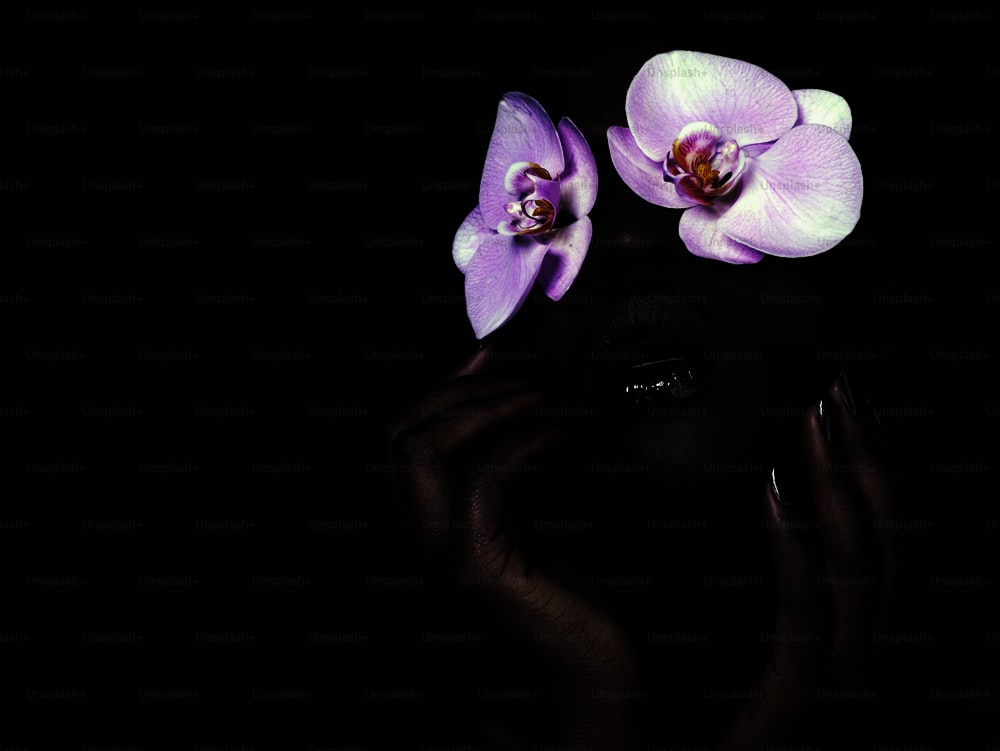 Eine Frau mit zwei Orchideen im Gesicht