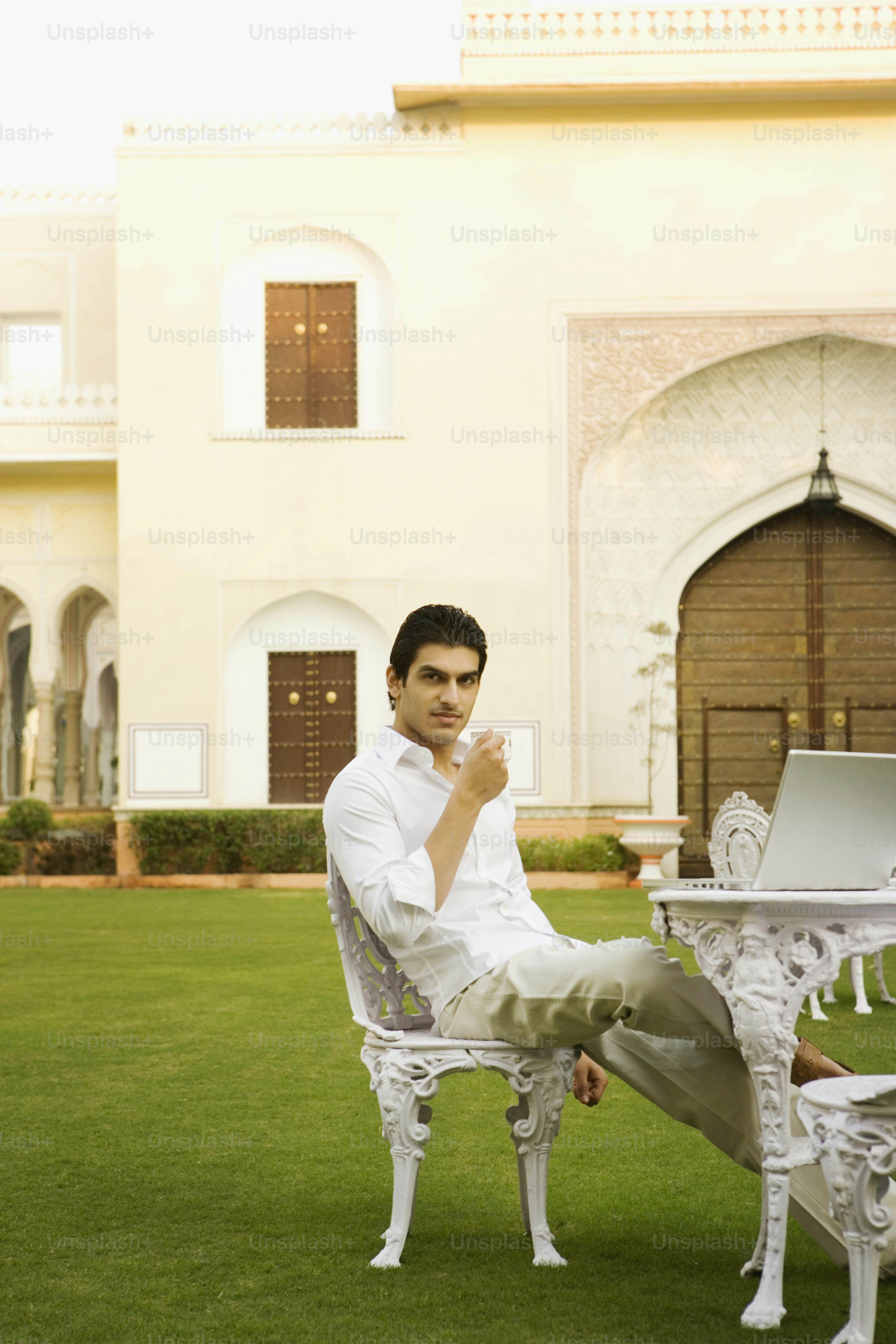 a man sitting on a chair in front of a laptop