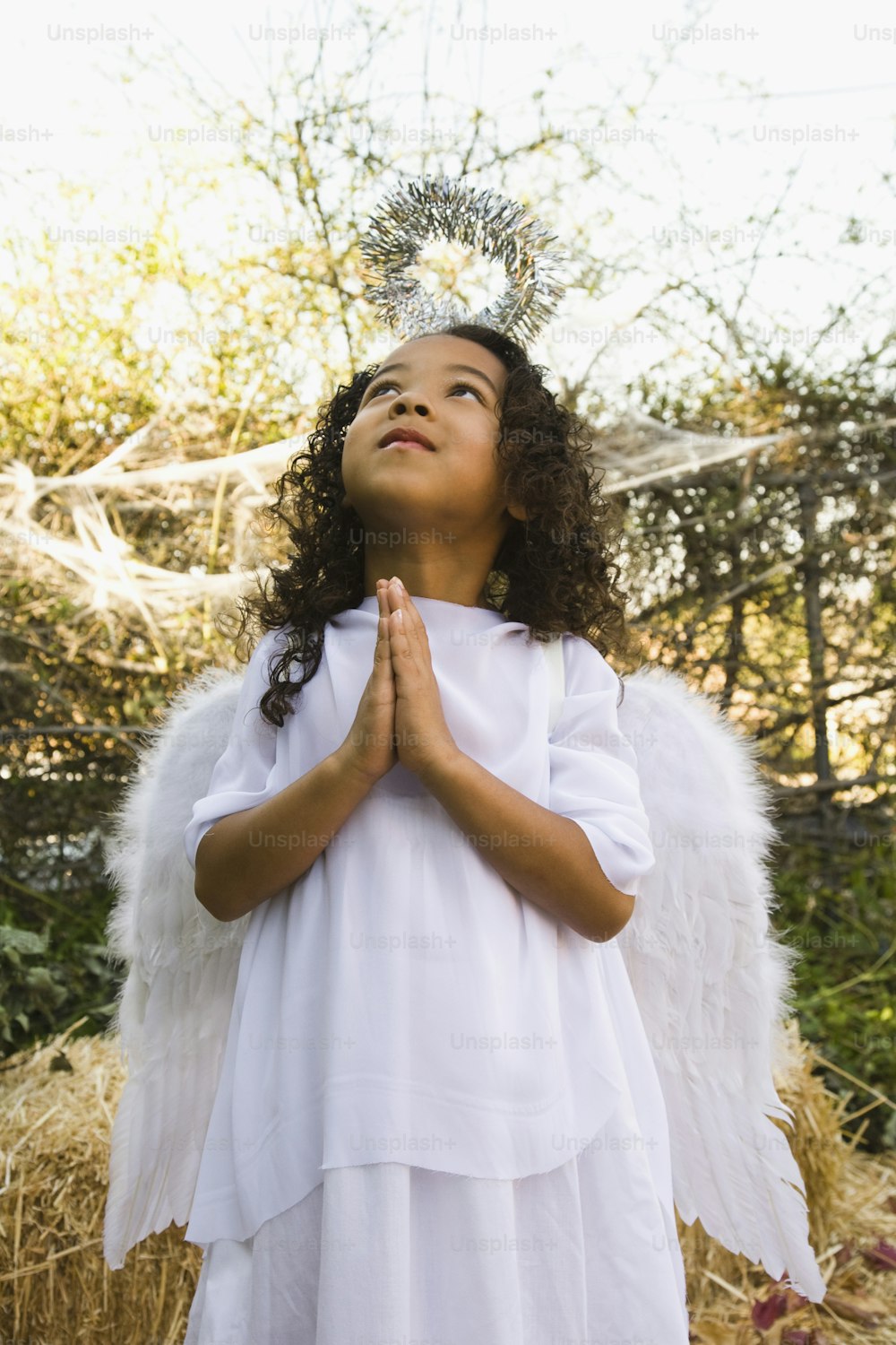a little girl dressed in a white angel outfit