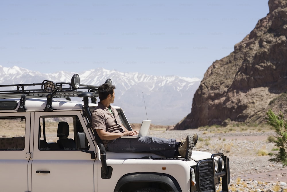 a man sitting on top of a white truck