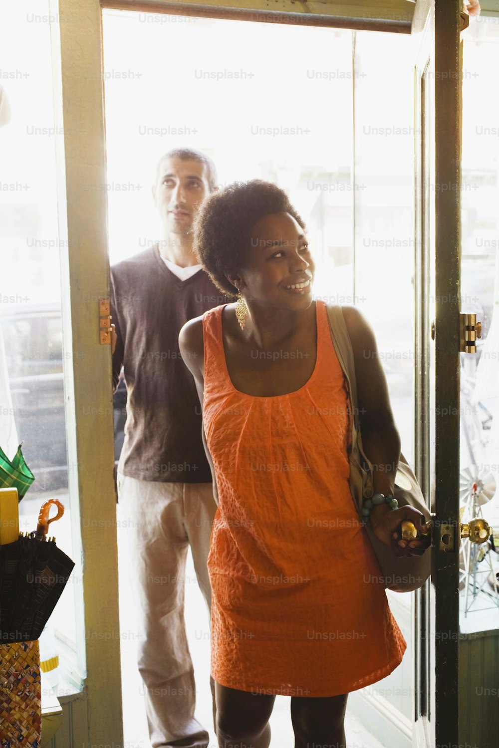 a woman in an orange dress standing in a doorway