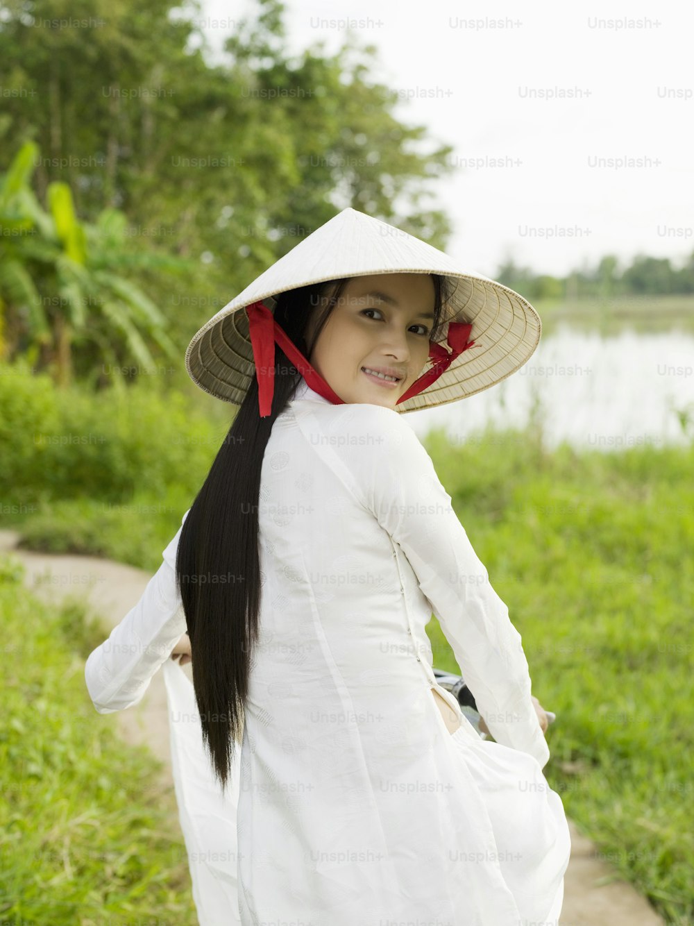 eine Frau in einem weißen Kleid und einem Hut