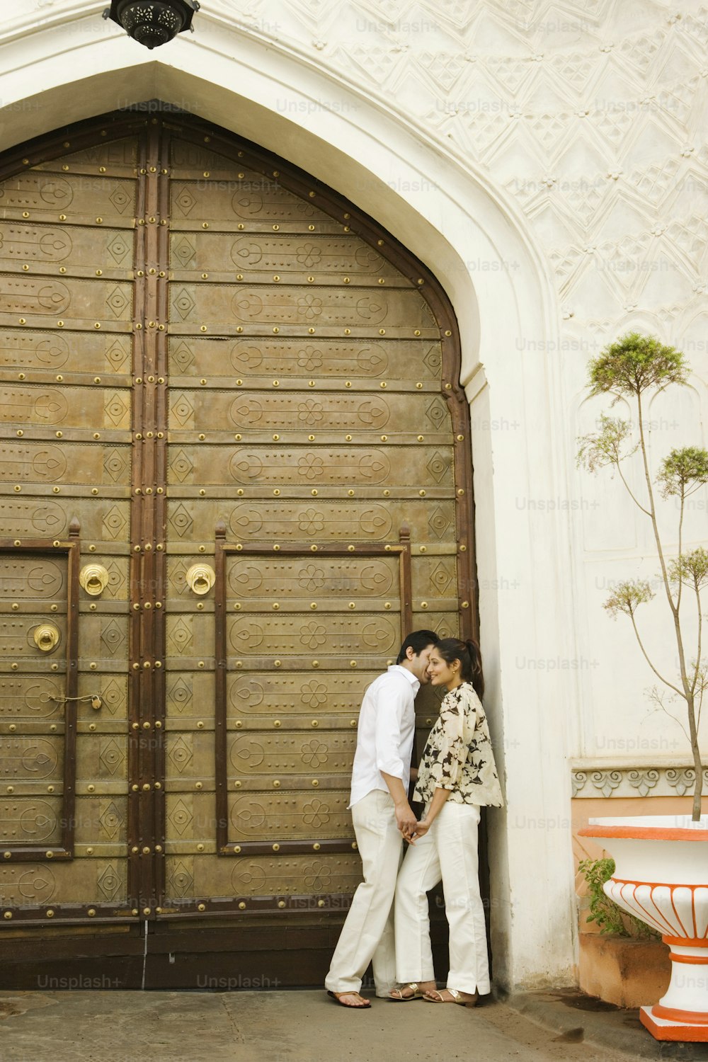 a man and a woman standing in front of a wooden door