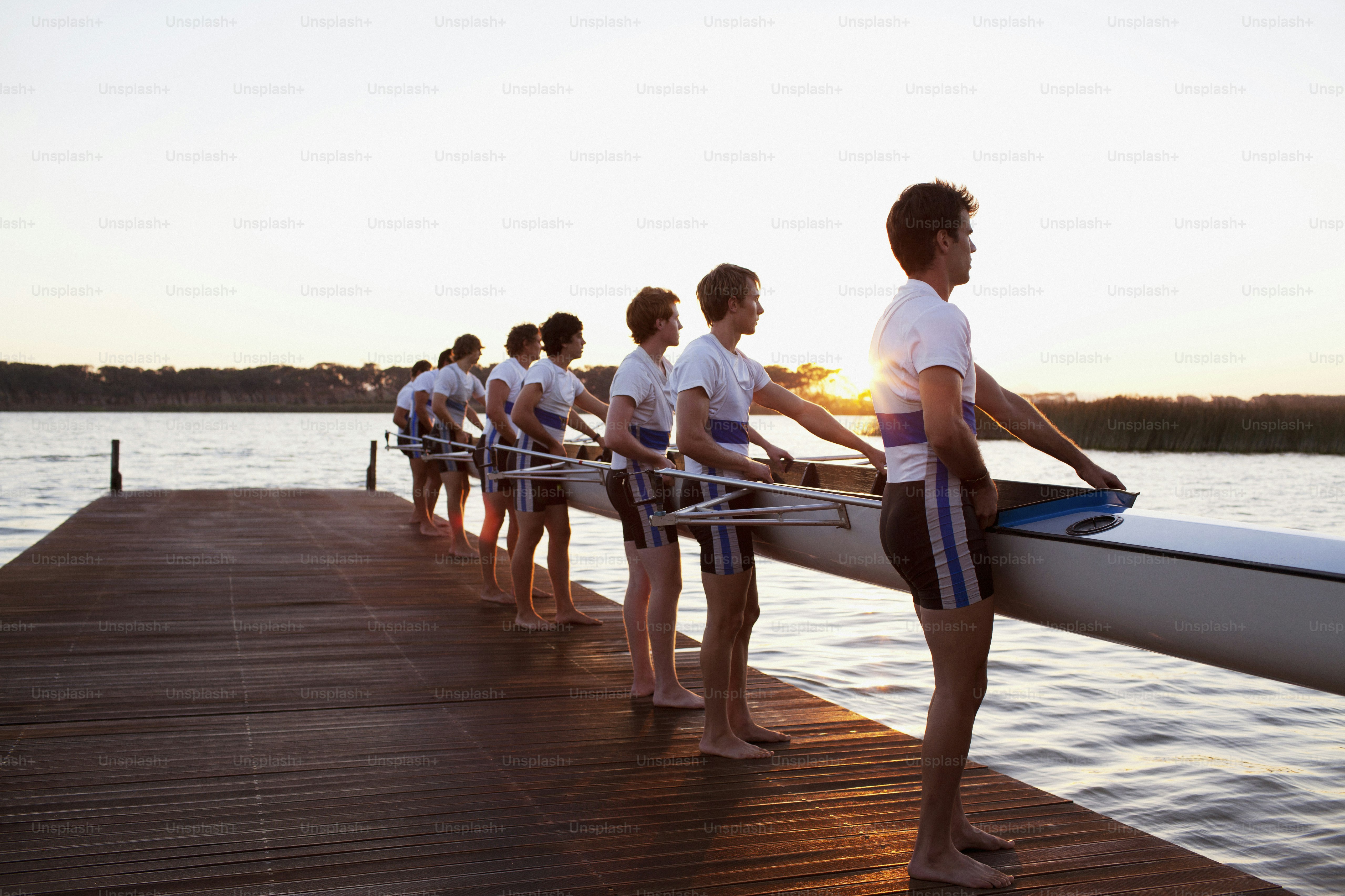 a group of people standing on a dock next to a body of water