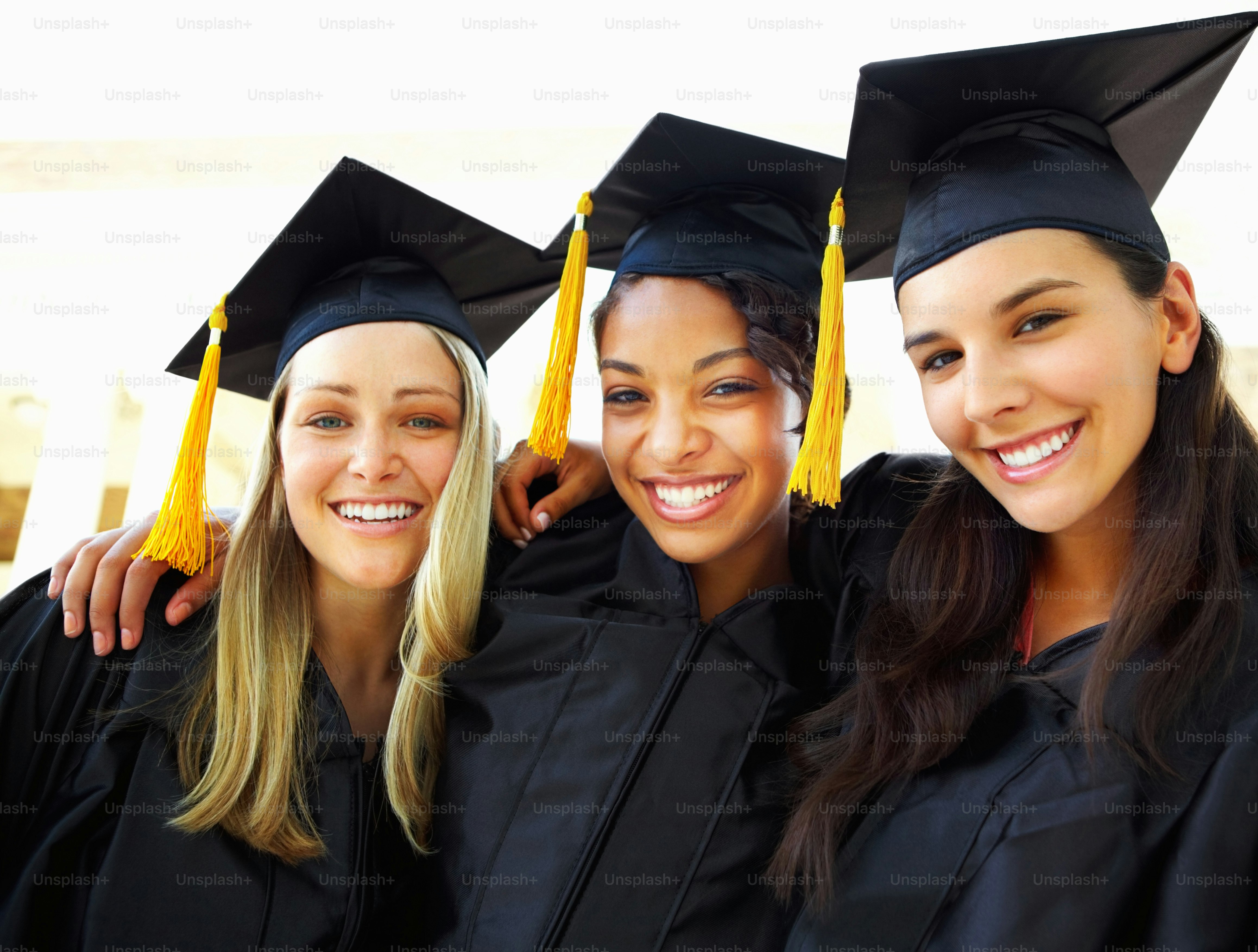 Happy young women in gowns celebrating their graduation photo ...