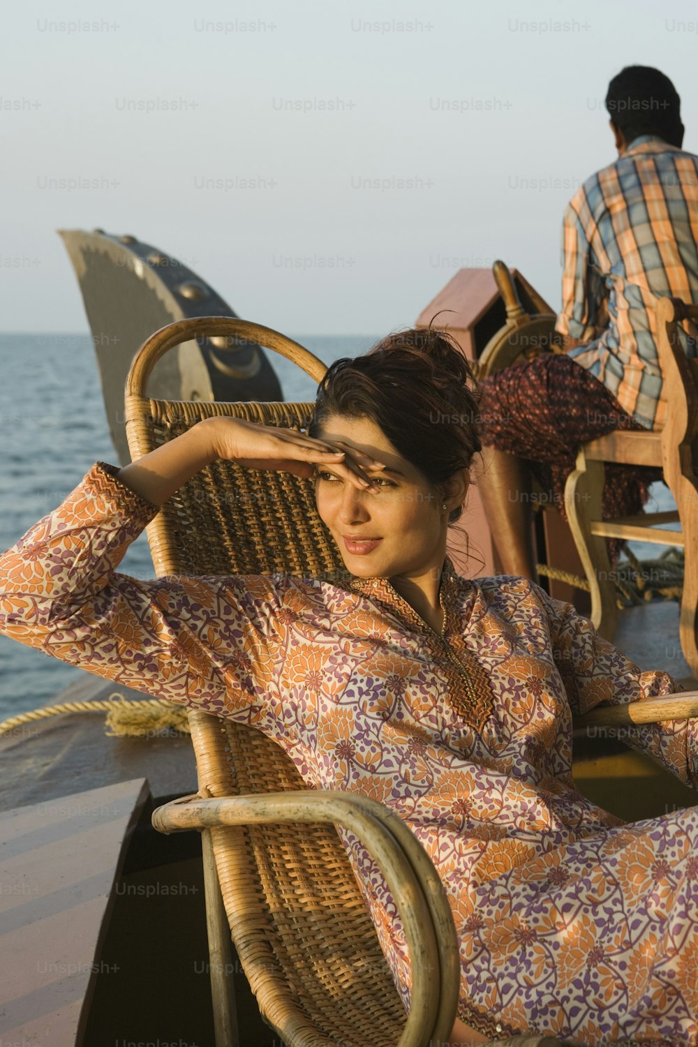 uma mulher sentada em cima de uma cadeira ao lado do oceano