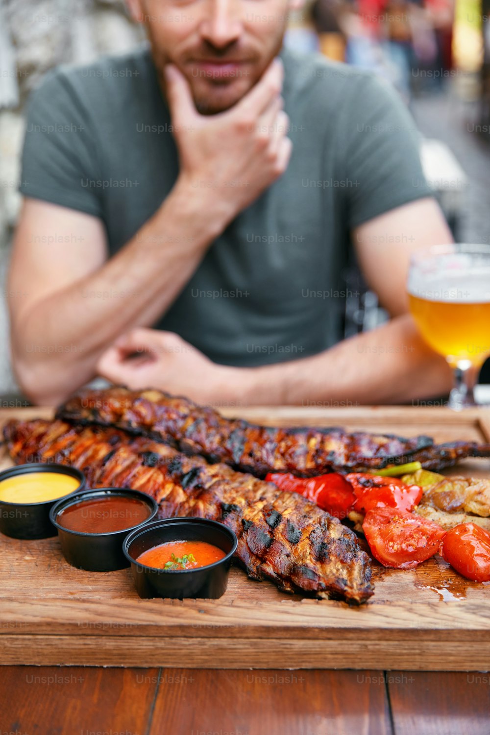 Barbecue Meat With Vegetables And Beer In Restaurant. Man Eating Grill Pork Ribs Closeup. High Resolution