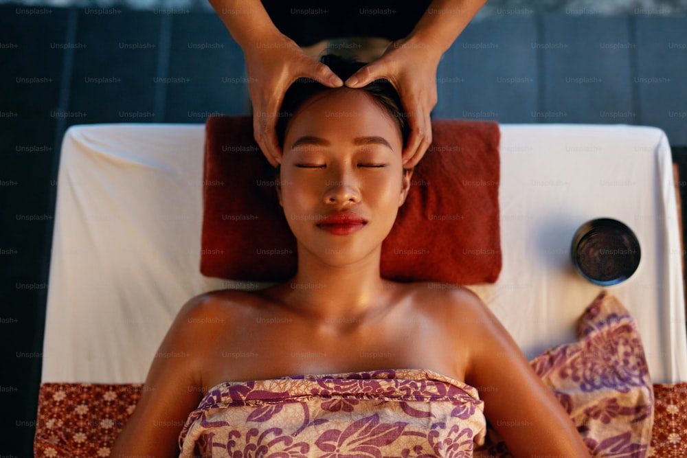 スパマッサージ。タイの美容院で女性の頭をマッサージする手。マッサージ療法を楽しんでいるアジアの女の子。高解像度
