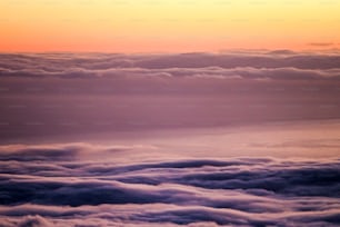 테네리페 엘 테이데 불칸에서 일몰 일몰의 높은 전망은 따뜻한 색상의 구름과 바다가 있는 라 고메라 방향을 바라보고 있습니다. 아름 다운 풍경 조용하고 침묵 장면