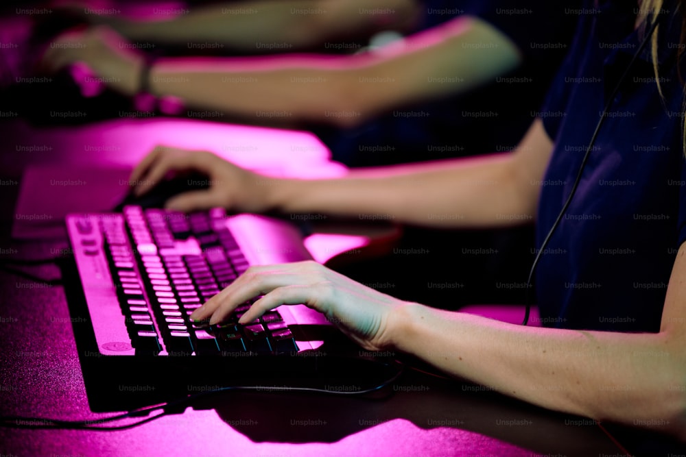 Hände einer jungen Betreiberin eines Callcenters, die Tasten der Computertastatur berührt, während sie einen Kunden konsultiert oder ein Videospiel spielt