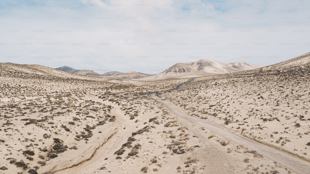 Estrada do caminho no meio de um deserto de areia das montanhas com céu azul brilhante ao fundo. Conceito de desertificação ou mudança climática para o aquecimento global. Incrível destino de viagem cênica