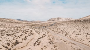 Weg Straße in der Mitte einer Berge Sandwüste mit blauem hellem Himmel im Hintergrund. Konzept der Wüstenbildung oder des Klimawandels für die globale Erwärmung. Erstaunliches malerisches Reiseziel