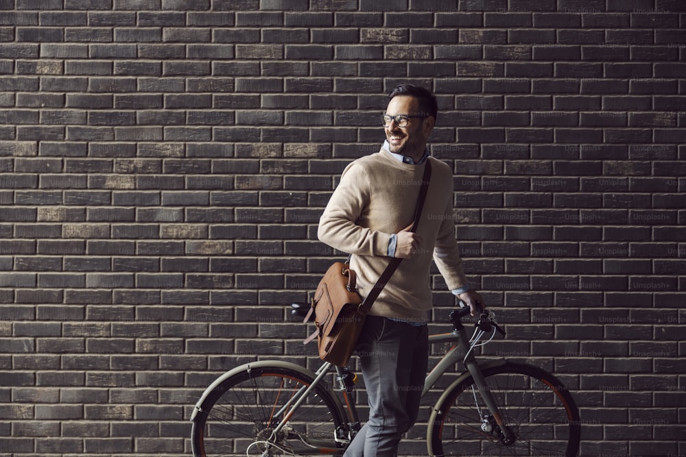 A city man pushing bicycle on the street.