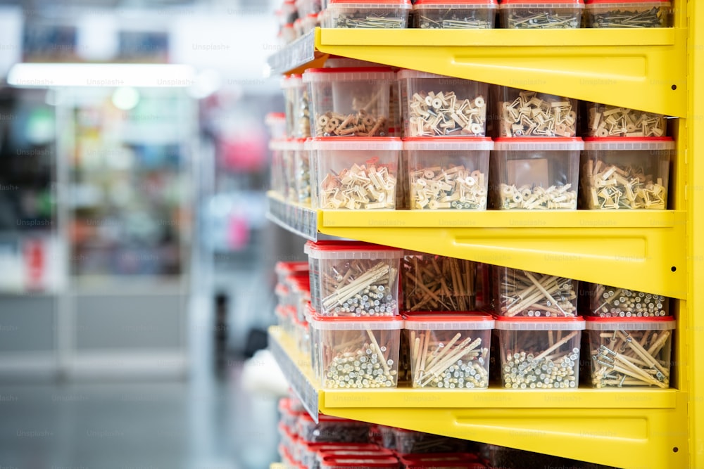 Side view of shelves with stacks of plastic containers with nails