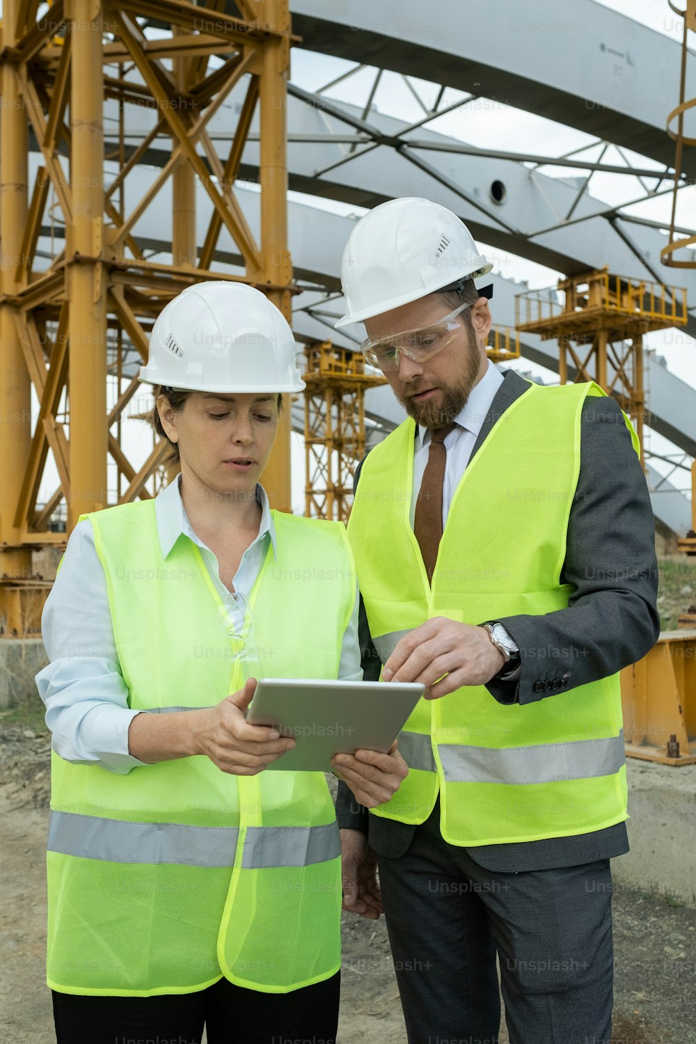 Small group of engineers scrolling through data on tablet screen