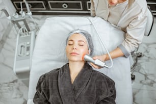 Woman during the oxygen mesotherapy procedure at the beauty salon, close-up view. Concept of a professional facial treatment