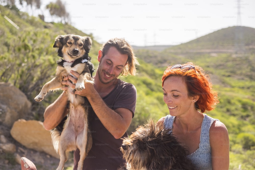 alternative outdoor living lifestyle family and couple in friendship and relationship have fun with their two dogs. happiness together in outdoor leisure activity. nature country side