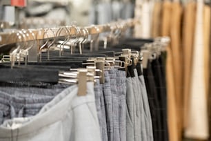 Variety of new trendy casual clothes hanging in row on rack