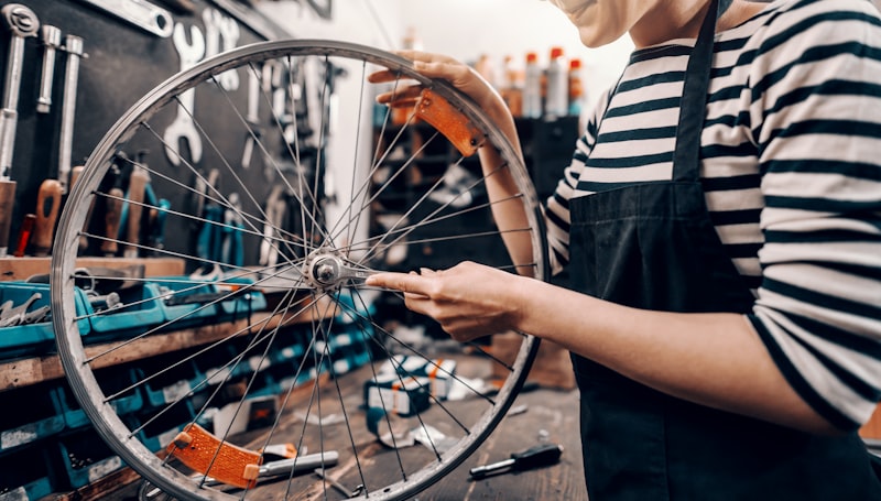 Technician assembling bicycle wheel in workshop